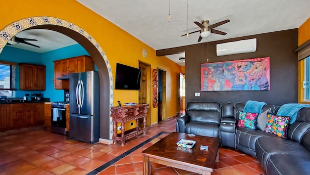 A living room with a sofa, coffee table, and a television. - Beautiful Apartment with amazing views ! A hidden gem! (San José del Cabo)