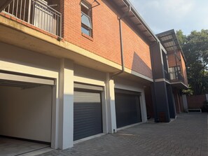 Ein zweistöckiges Gebäude mit Garage und Balkon.