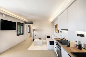 A modern kitchen with built-in appliances, a flat-screen TV, and a minimalist design.
