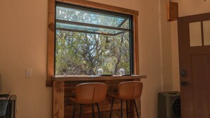 Ein Zimmer mit einem großen Fenster, zwei Stühlen und einer Tür.