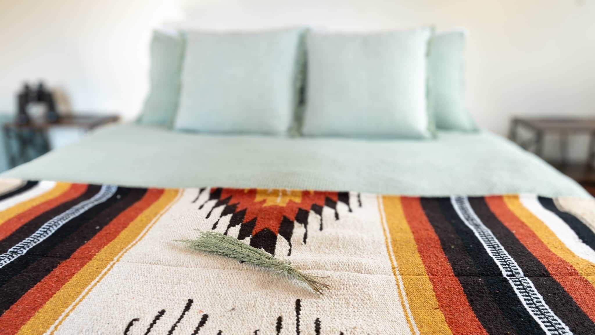 Una cama con un edredón a rayas y dos almohadas.