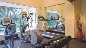 A gym with treadmills, an elliptical, and free weights. - Tropicana Resort and Spa Alibaug (Alibag)