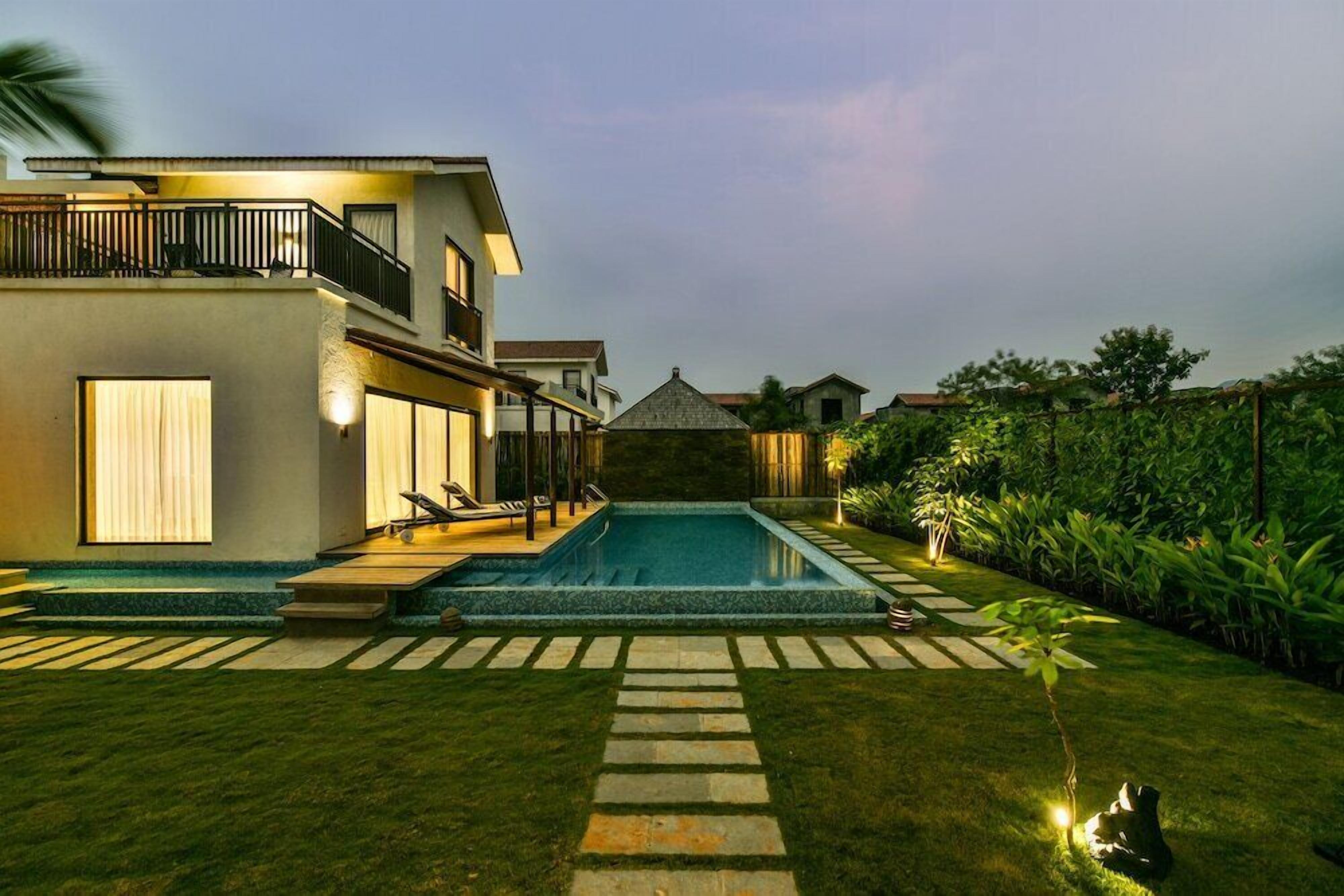 A residential property with a swimming pool, a covered patio, and a well-maintained garden.
