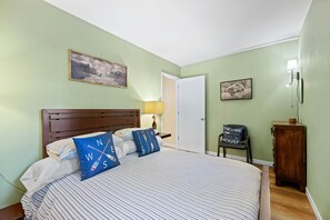 A bedroom with a bed, a nightstand, a chair, a lamp, and a door. - Cortina Chalet - Cozy Lake Tahoe Retreat / Walk to Diamond Peak (Incline Village)
