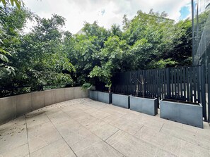 A courtyard with a curved pathway, concrete planters, and a black fence. - Insurgentes Roma Sur by Wynwood House (Ciudad de México)