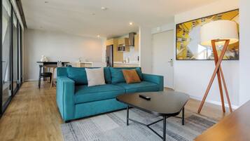 Uma sala de estar moderna com um sofá verde-água, uma mesa de centro e um abajur.