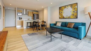 A modern living room with a sofa, coffee table, and a dining area with chairs and a table. - Insurgentes Roma Sur by Wynwood House (Ciudad de México)