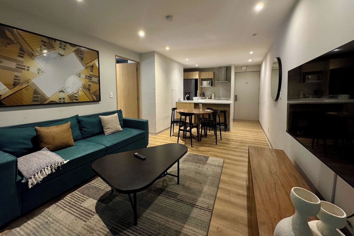 Uma sala de estar moderna com sofá, mesa de centro e um espaço de jantar com cadeiras e mesa.