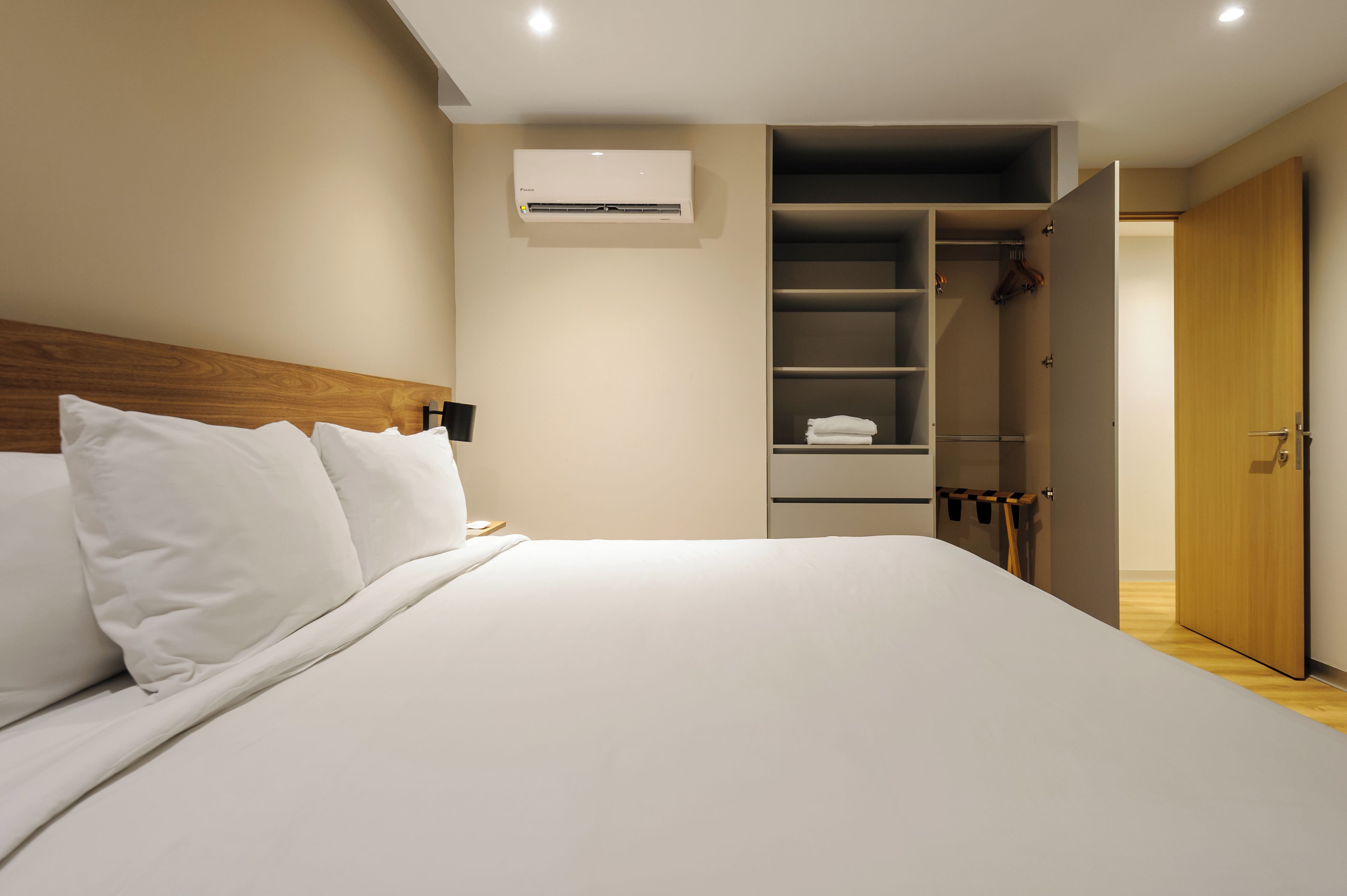 Habitación de hotel con cama, armario y aire acondicionado instalado.