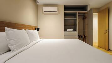 Habitación de hotel con cama, armario y aire acondicionado instalado.