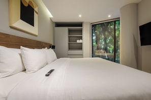 Cama bem arrumada com lençóis brancos e um controle remoto.