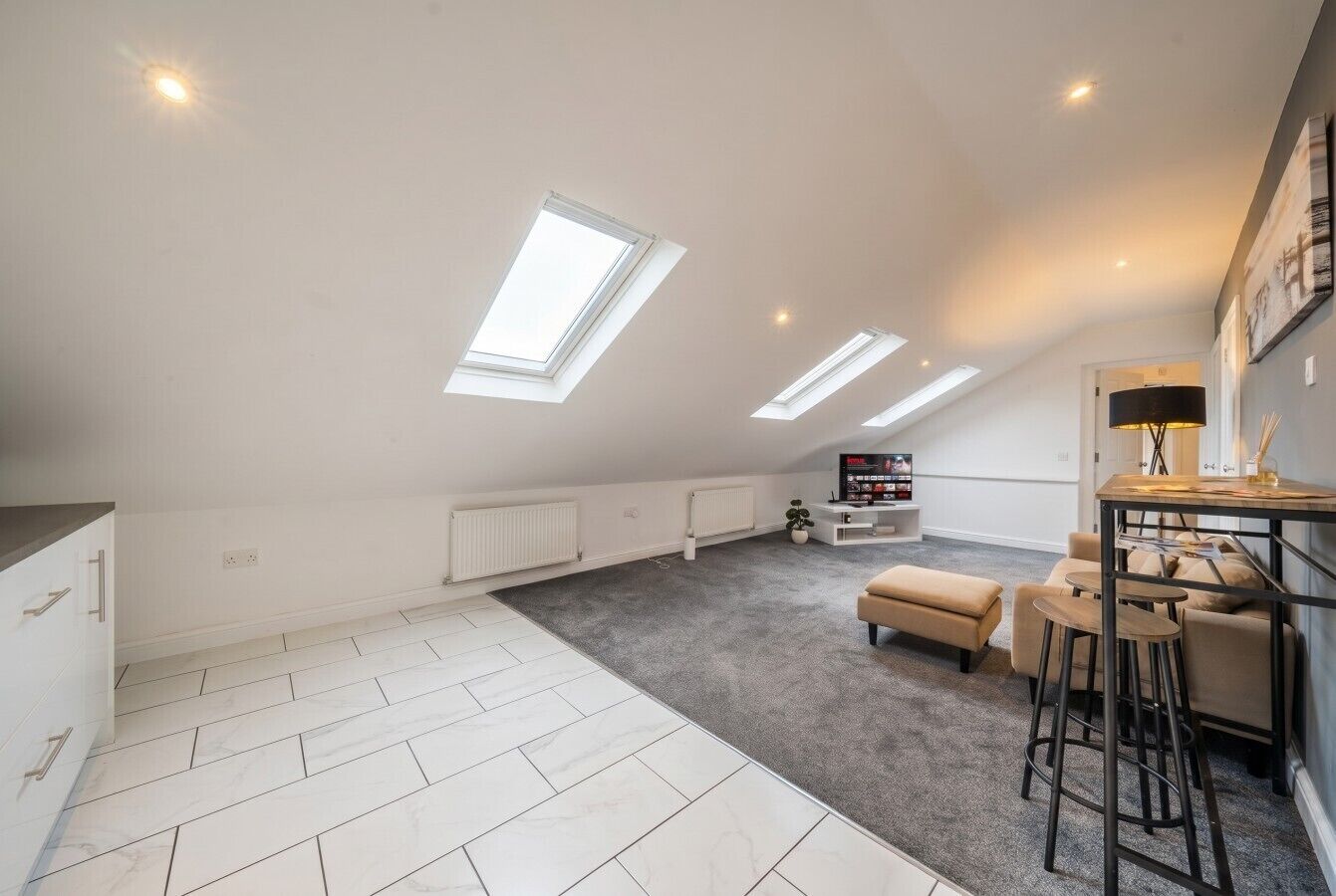 Sunlit living and dining area where sloped ceilings and skylights create real character.