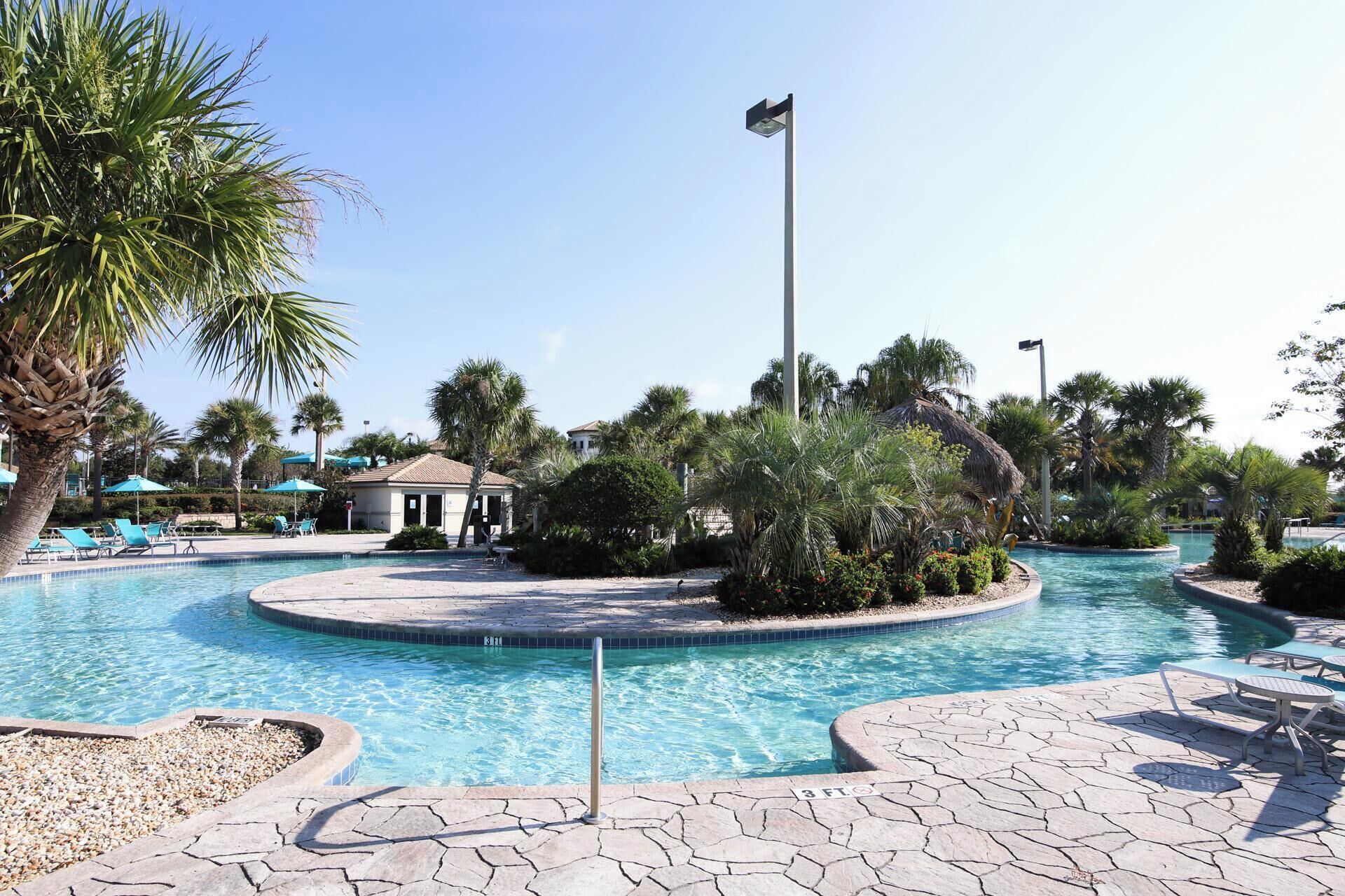 A pool area with lounge chairs, a gazebo, and a flagpole.