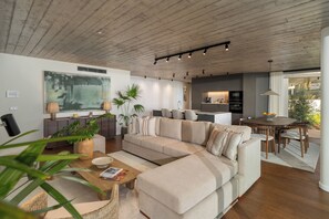 Un salon moderne comprenant un canapé, une table basse et un coin repas avec une table et des chaises.