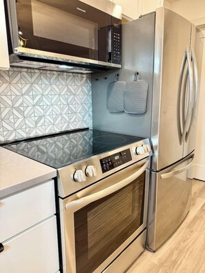 A kitchen with a stainless steel refrigerator, oven, and microwave. - Located in Downtown Kanab I All-New Home! (Kanab)