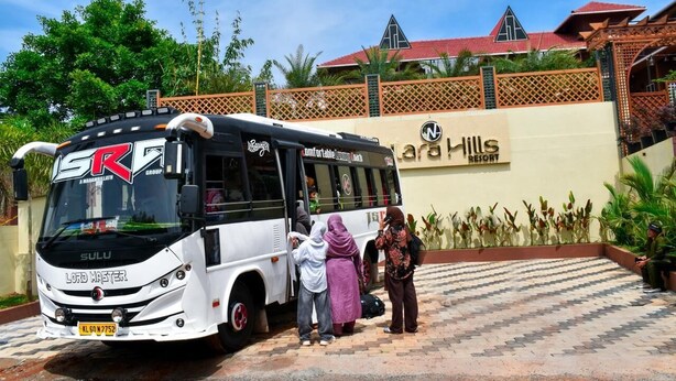 Een bus geparkeerd voor een gebouw met een bord waarop 'Car Hills Resort' staat.