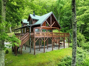 Eine Holzhütte mit einer Terrasse und einer Treppe zu einer zweiten Ebene.