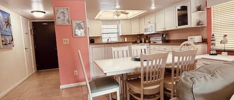 Un espace de vie compact comprenant un coin repas, une kitchenette et un canapé.