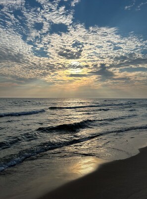 Ein Strand mit Wellen und einem bewölkten Himmel.