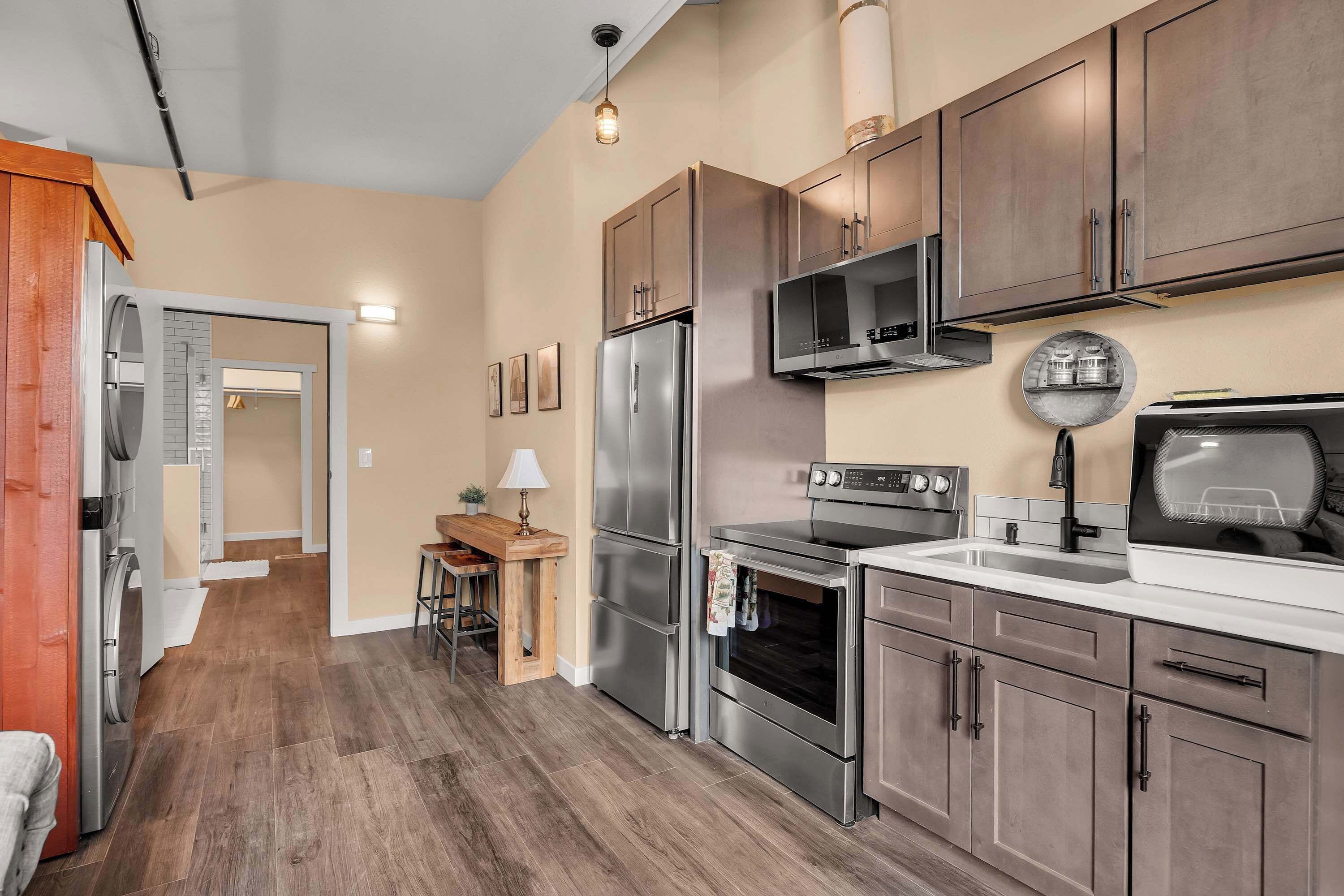 A modern kitchen with stainless steel appliances, wooden cabinets, and a built-in oven.