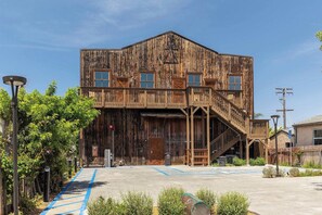 A rustic wooden building with a balcony, a ramp, and a parking area with blue accessibility markings. - OldTown Barnhouse 2Units Historic OldTown & Dining (San Diego)
