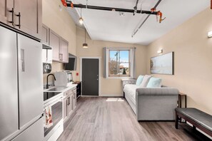 A compact living space with a kitchenette, a sofa, a window with a view, and a bench. - OldTown Barnhouse 2Units Historic OldTown & Dining (San Diego)