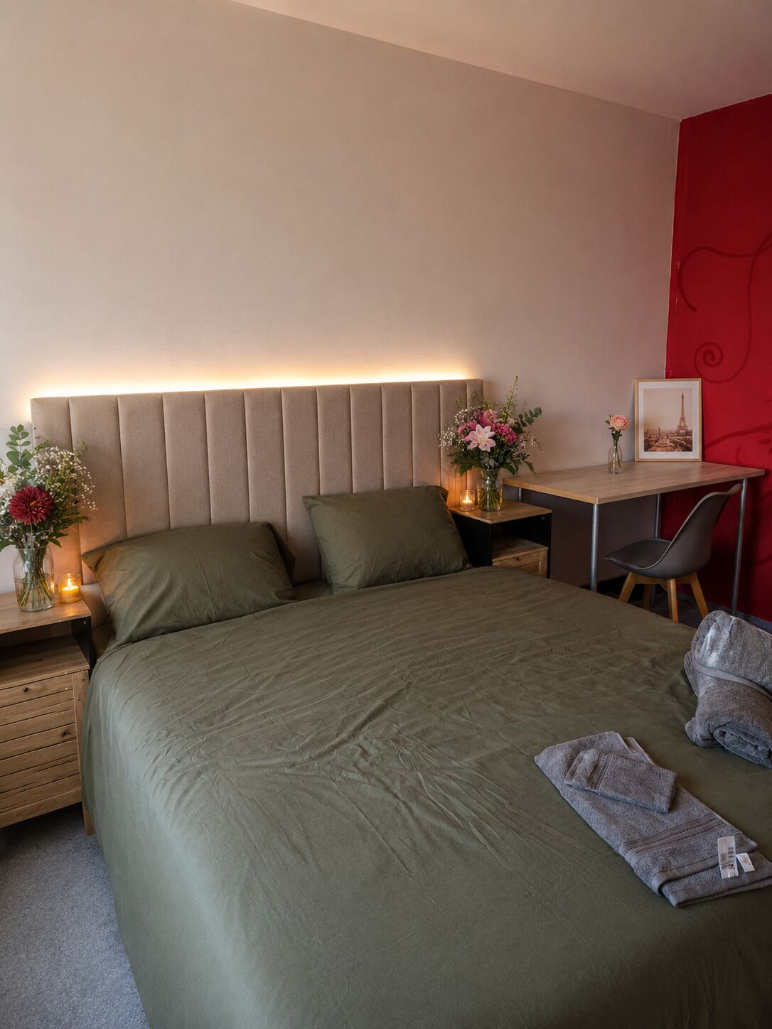 Habitació d'hotel moderna amb un llit gran, una taula de treball i una cadira.