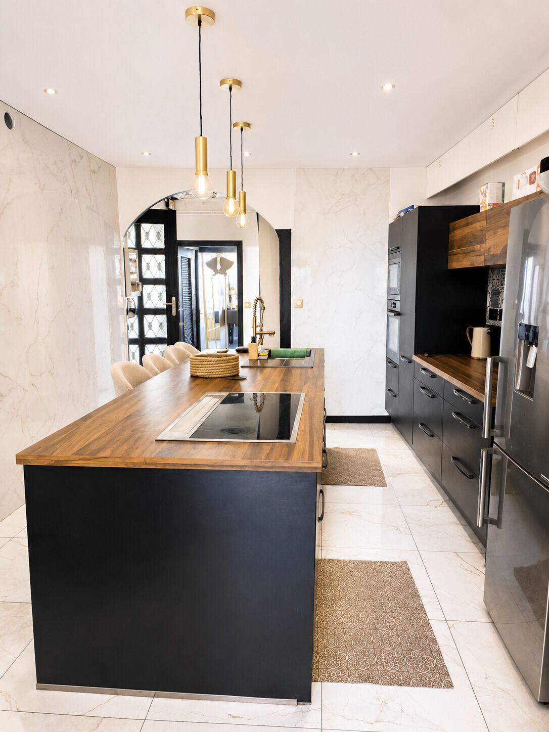 A modern kitchen with a central island, stainless steel appliances, and pendant lighting.