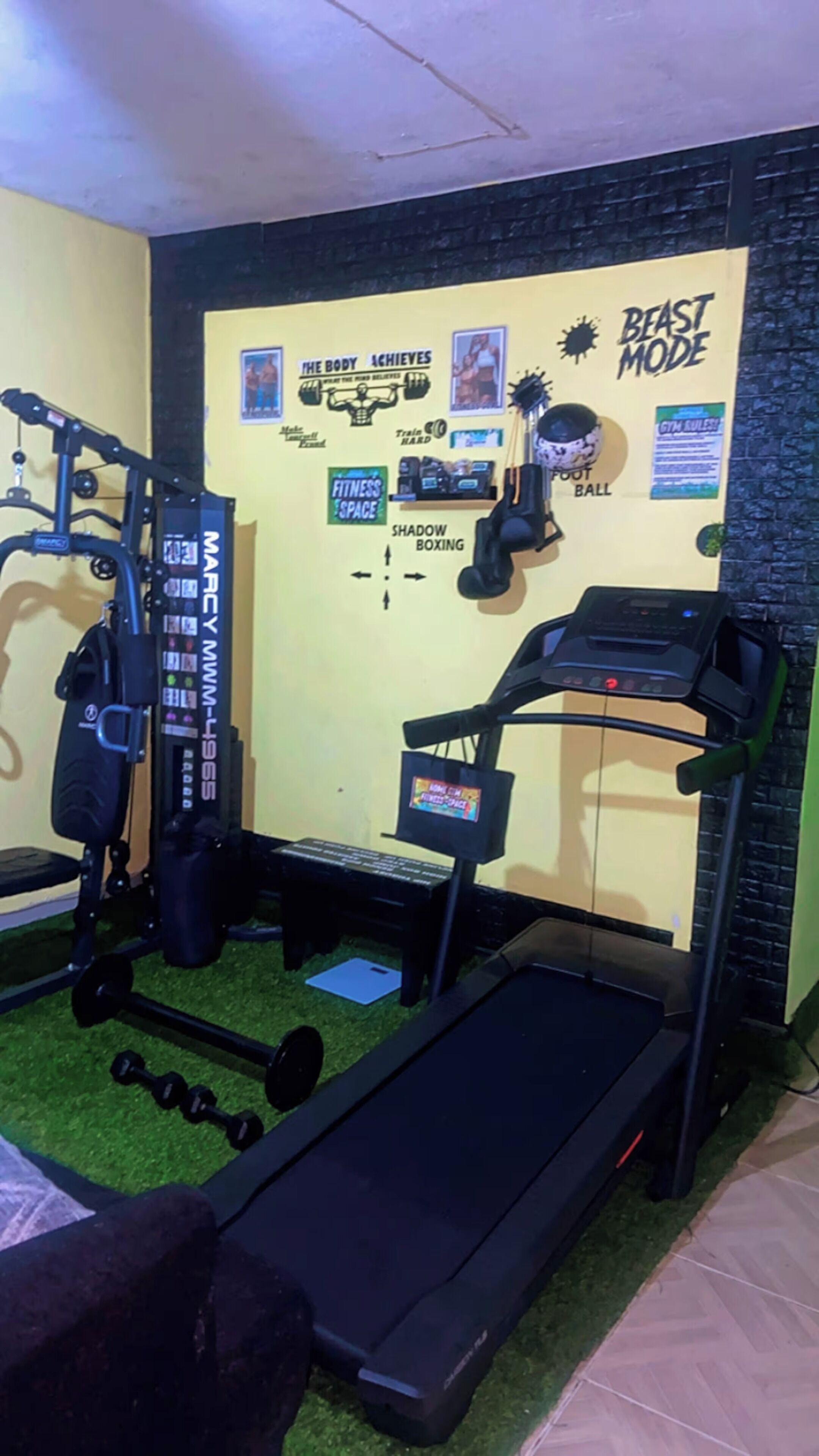 A gym with a treadmill, weight bench, and exercise equipment.