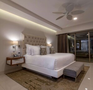 A modern bedroom with a large bed, bedside lamps, a ceiling fan, and a view through a glass door. - Cozy Studio, 1-bedroom, in welcoming Cabo San Lucas with a beautiful view. (Cabo San Lucas)