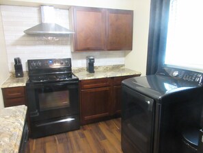 A kitchen with a stove, oven, microwave, and a coffee maker. - Three Kings Retreat - East Memphis (Memphis)
