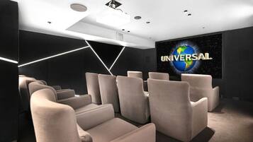 A modern home theater with a large screen displaying the word 'UNIVERSAL' and a starry sky background.