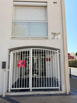A building with a gated entrance, a sign indicating 'Port Bressou 1' and 'Est. 100', and a no parking sign. - Studio 4 pers Port Cap d'Agde · Plage (Agde)
