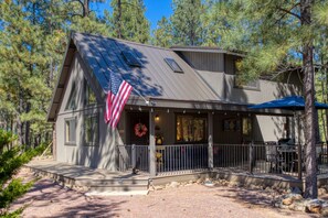 A cabin with a porch, an American flag, and a mountain view. - Cozy Bear Themed Cabin in Pinetop Country Club (Pinetop Country Club)