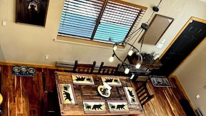 A dining area with a wooden table, chairs, and a chandelier. - Cozy Bear Themed Cabin in Pinetop Country Club (Pinetop Country Club)