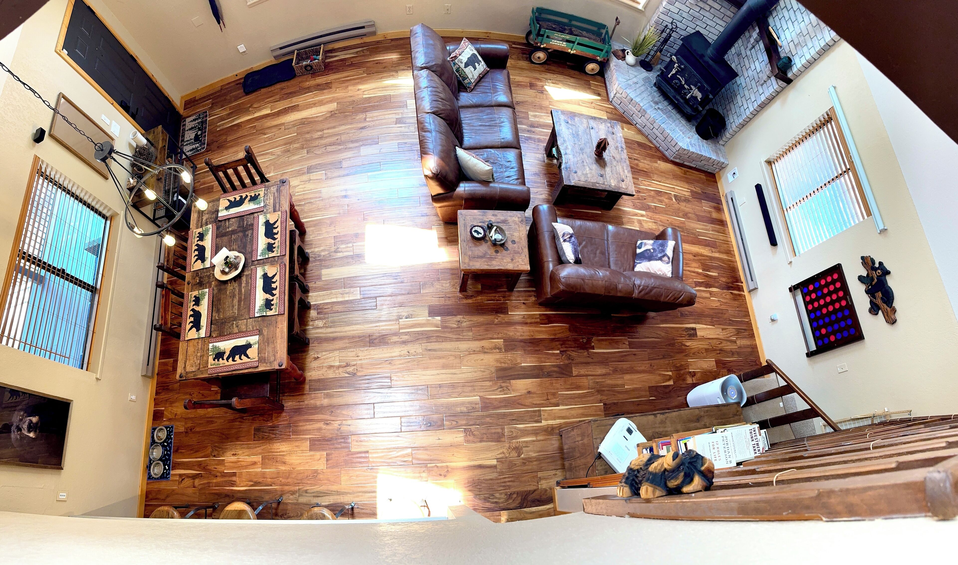 A living room with a wooden floor, leather sofas, a coffee table, and a fireplace.