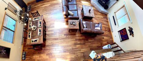 A living room with a wooden floor, leather sofas, a coffee table, and a fireplace.