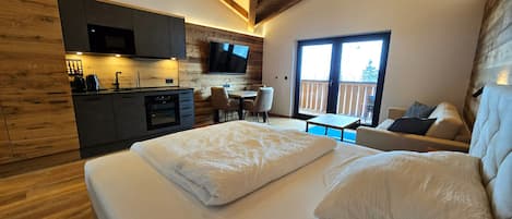Un dormitorio moderno con una cama grande, una mesita y un sofá.