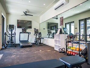 A gym with treadmills, elliptical machines, a bench, and a rack of kettlebells. - REMAINING 2026 $200/nt! Luxury!Ocean & Haleakala Views.1 Bed/ 2 Bath.Huge Lanai! (Wailea)