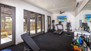 A gym with exercise equipment, a bench, and large windows overlooking a deck. - Fall $250 Wailea Luxury Escape.Ocean & Haleakala Views.1 Bed/ 2 Bath.Huge Lanai! (Wailea)