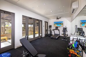 A gym with exercise equipment, a bench, and large windows overlooking a deck. - Fall $250 Wailea Luxury Escape.Ocean & Haleakala Views.1 Bed/ 2 Bath.Huge Lanai! (Wailea)