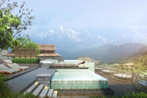 A resort with a pool, lounge chairs, and a mountain backdrop. - Dusit Thani Himalayan Resort (Dhulikhel)