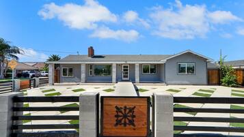 A single-story house with a front entrance, a driveway, and a gated driveway.