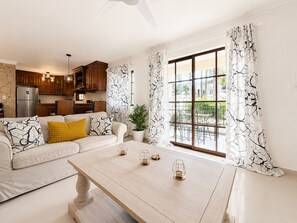 Ein modernes Wohnzimmer mit einer Couch, einem Couchtisch und Blick auf die Terrasse.