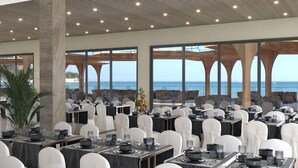 A spacious dining area with tables set for service, large windows offering a view of the sea, and a modern architectural design with a high ceiling. - Sirena Beach Resort & Spa (Marsa Alam)