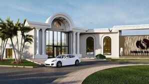 A modern hotel entrance with a white facade, palm trees, and a white car parked in front. - Sirena Beach Resort & Spa (Marsa Alam)