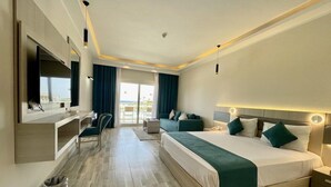 A hotel room with a large bed, a desk, a TV, and a view of the outdoors. - Sirena Beach Resort & Spa (Marsa Alam)