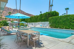 A pool area with lounge chairs, umbrellas, and a view of a mountainous landscape. - No Paparazzi - Palm Springs Paradise: Your Private Poolside Retreat Awaits (Palm Springs)