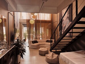 A modern interior with a staircase, a sofa, and a dining area. - Provenza Luxury Terrace (Medellín)