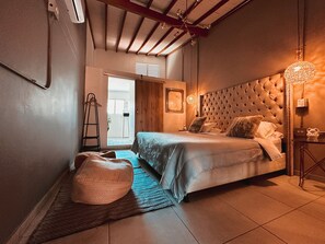 A bedroom with a large bed, a wooden ceiling, and a small bedside table. - Provenza Luxury Terrace (Medellín)